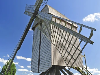 Bockwindmühle Neuenknick Historische Bockwindmühle mit hölzernem Aufbau auf Wiese, unter klarem blauen Himmel in Neuenknick.