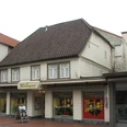 Lange Straße 89 Historisches Fachwerkhaus mit Uhr an der Fassade, darunter ein Juwelier-Geschäft in einer Einkaufsstraße.