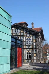 Junkerhaus Lemgo Fachwerkhaus mit kunstvoll verzierten Fassaden und rotem Eingangsbereich unter blauem Himmel.