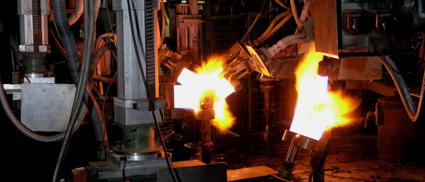 Flammen erhitzen Glas in einer industriellen Produktionsumgebung bei der Glasherstellung.