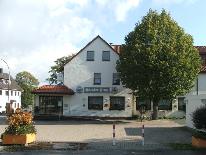 Hörster Krug Gebäude mit weißer Fassade, dem Schriftzug "Hörster Krug" und seitlichem Zugang mit Rampe.