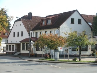 Hörster Krug Historisches Gasthaus Hörster Krug mit weißen Fassaden und rotem Ziegeldach an einer Straßenecke.