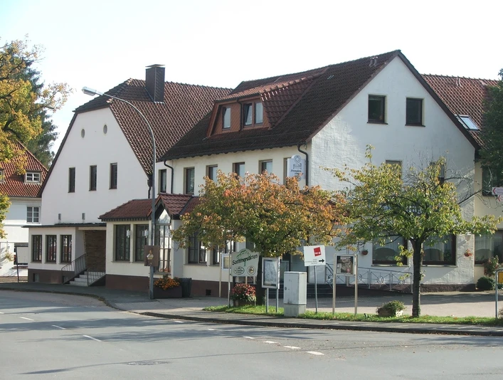 Hörster Krug Historisches Gasthaus Hörster Krug mit weißen Fassaden und rotem Ziegeldach an einer Straßenecke.