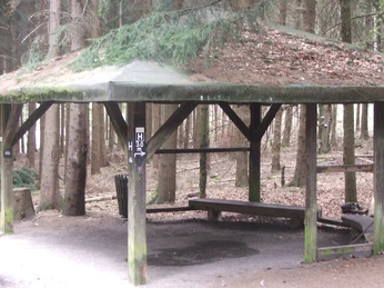 Schutrzhütte Hermannsweg 2 Offene Schutzhütte im Wald mit hölzernem Dach, umgeben von Bäumen, bietet Schutz und Rastmöglichkeit.