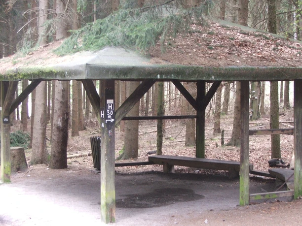 Schutrzhütte Hermannsweg 2 Offene Schutzhütte im Wald mit hölzernem Dach, umgeben von Bäumen, bietet Schutz und Rastmöglichkeit.