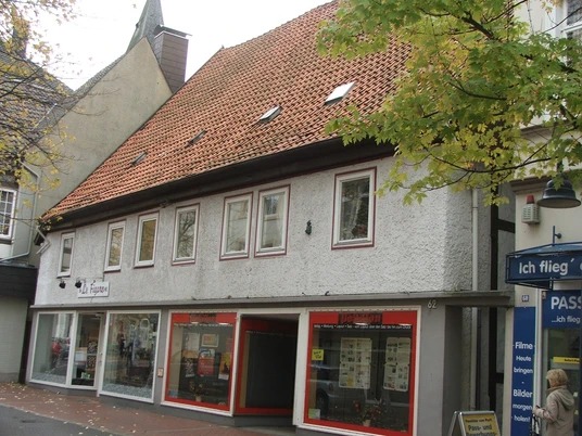 Haus Drüke Das Gebäude mit rotem Ziegeldach beherbergt ein Fotofachgeschäft und liegt in einer belebten Straße.