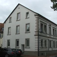 Haus Rhienstraße 30 Ein dreistöckiges weißes Wohnhaus aus dem 19. Jahrhundert mit markanten Fenstereinfassungen.
