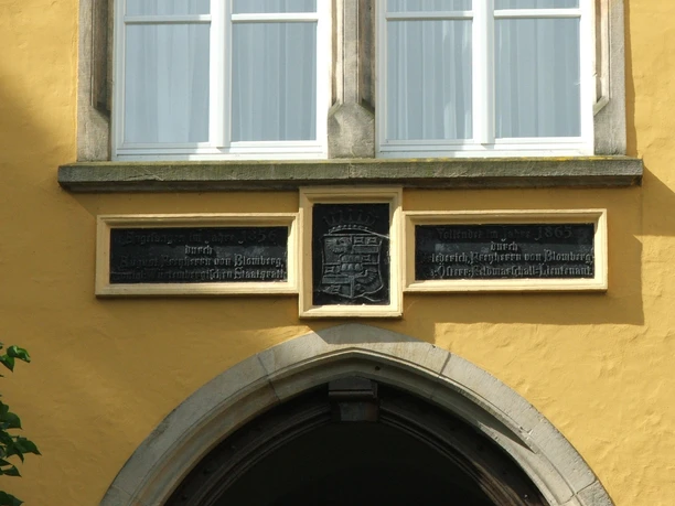 Schloss Iggenhausen In Stein gemeißelte Tafeln und Fenster an der Fassade eines historischen Gebäudes.