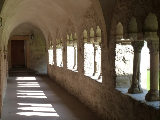 Kreuzgang (Pürting) der Busdorfkirche Sonnenlicht durchflutet gewölbten mittelalterlichen Kreuzgang mit Säulen und Steinwänden in Pürting.