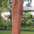 Stele im Friedenpark Backsteinstele im Park von Bäumen umgeben, symbolisiert Reflexion und Ruhe im öffentlichen Raum.