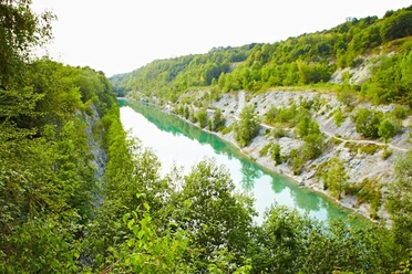 Lengericher Canyon Smaragdgrüner See eingerahmt von bewaldeten Klippen, umgeben von üppiger Vegetation.