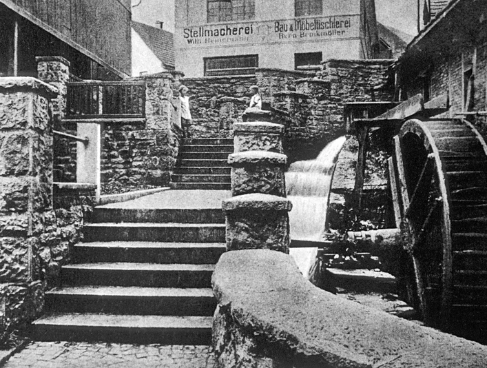 Mühlenpforte um 1910 Historische Aufnahme der Mühlenpforte um 1910 mit Wasserrad und steinernen Treppenstufen.