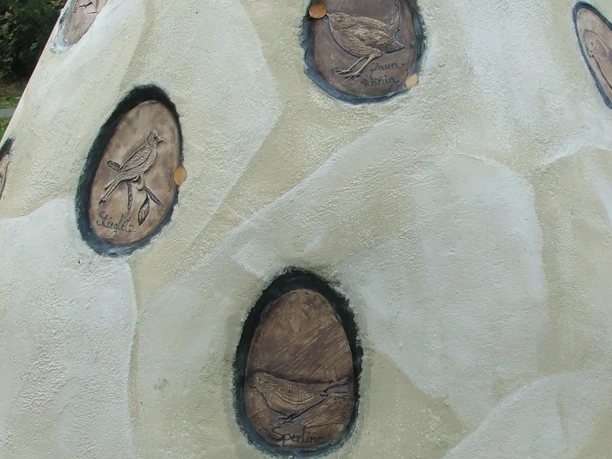 Horst von Hörste - Ausschnitt Kunstvoll gestaltete Skulptur mit ovalen Einsätzen, die verschiedene Vogelarten stilvoll darstellen.