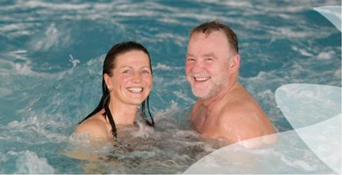 Badende Kurmittelhaus SoleVital Bad Laer Zwei lächelnde Personen genießen ein Bad im Innenpool des SoleVital Kurmittelhauses in Bad Laer.