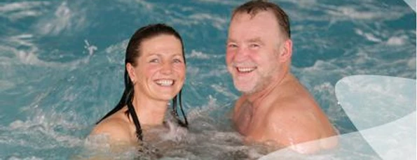 Badende Kurmittelhaus SoleVital Bad Laer Zwei lächelnde Personen genießen ein Bad im Innenpool des SoleVital Kurmittelhauses in Bad Laer.