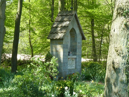 Annabild bei Borchen-Dörenhagen Steinkapelle im Wald bei Borchen-Dörenhagen umgeben von Frühjahrsblumen und lichten Bäumen.