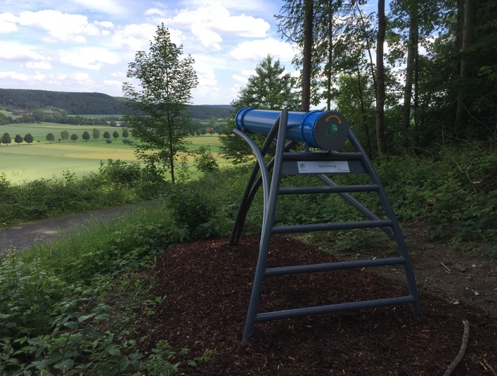 Aussichtsplattform mit modernem Sphäriskop bietet Panoramablick über grüne Felder und Wälder Alhausens.