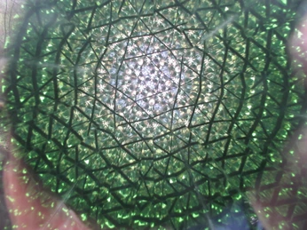 Hier sieht man sich selbst vielfach fragmentiert (in diesem Fall die Kamera) Kaleidoskopische Ansicht: Die Kamera fängt ein vielfach reflektiertes, grünes geometrisches Muster ein.