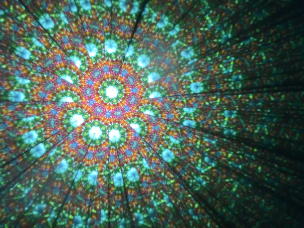 Im klassischen Kaleidoskop formen bunte Kugeln und Perlen unendliche Muster Blick ins Innere des Kaleidoskop wo bunte Muster entstehen.