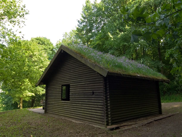 Rückseite von einer Schutzhütte die neben dem Kaleidoskop steht.