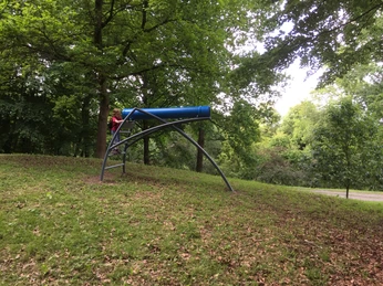Das Kaleidoskop liegt oberhalb einer kleinen Obstwiese Mädchen steht am Kaleidoskop das oberhalb einer kleinen Obstwiese liegt.