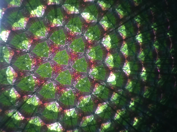 Farbenfrohes Kaleidoskop-Muster mit langsamer Bewegung, zeigt harmonische Anordnung sich wandelnder Formen.