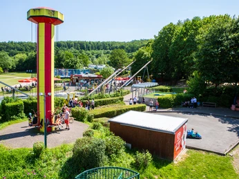 SchiederSee - Familien-Freizeitpark "Funtastico" Hoch über der bunten Landschaft erhebt sich ein leuchtend gelber Aussichtsturm im Familien-Freizeitpark.