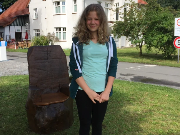 Selfie Point vor dem Campingplatz am Furlbach in SHS Selfie-Point vor einem roten Backsteinhaus, junger Mensch posiert auf einem gelben Podest.