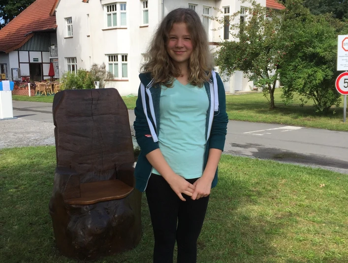 Selfie Point vor dem Campingplatz am Furlbach in SHS Selfie-Point vor einem roten Backsteinhaus, junger Mensch posiert auf einem gelben Podest.