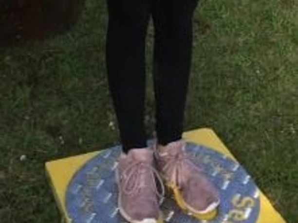 Selfie Point Campingplatz Am Furlbach gut sichtbar auf gelber Steinplatte Gelbe Steinplatte mit Aufschrift "Selfie Point Campingplatz Am Furlbach", zwei Schuhe darauf.