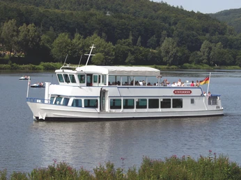 SchiederSee mit Schifffahrt Weißes Ausflugsschiff mit Passagieren gleitet auf einem See, umgeben von grünen Wäldern und sanften Hügeln.