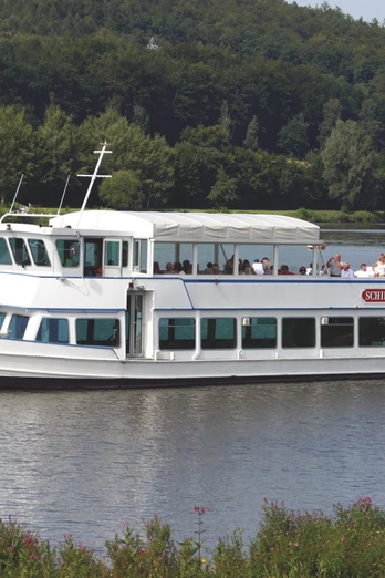 SchiederSee mit Schifffahrt Weißes Ausflugsschiff mit Passagieren gleitet auf einem See, umgeben von grünen Wäldern und sanften Hügeln.