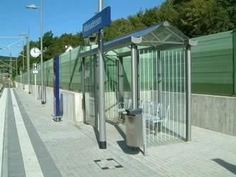 Bahnhof Willebadessen Moderner Bahnsteig in Willebadessen mit überdachter Wartehalle, Sitzfläche und klarer Ausschilderung.