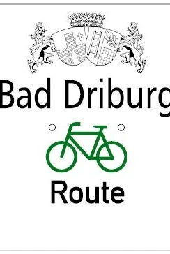 Wegweiserschild mit Aufschrift "Bad Driburg Route" und grünem Fahrradsymbol zur Orientierung.