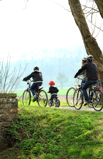 Radler am Boker Kanal Radfahrer, darunter ein Kind, fahren entlang eines grünen Weges am Ufer des Boker Kanals entlang.