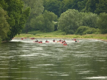 Mit dem Kanu auf der Weser Kanus gleiten auf der mäandrierenden Weser inmitten grüner Uferlandschaft und dichter Wälder.