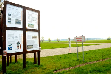 Römerlager Anreppen Infotafel und Wegweiser im Römerlager Anreppen, umgeben von einer weiten Wiesenlandschaft.