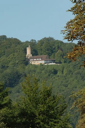 Die Iburg ist ein beliebter Ausflugsort der Region. Iburg mit Turm erhebt sich majestätisch im Wald, von grünen Bäumen umgeben, sonnenbeschienen.