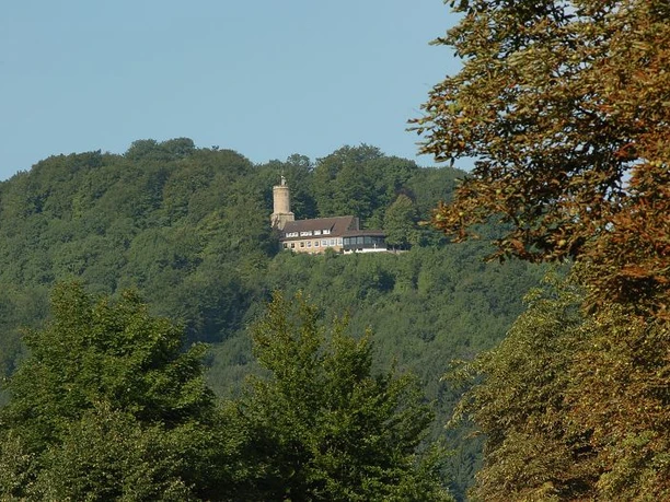 Die Iburg ist ein beliebter Ausflugsort der Region. Iburg mit Turm erhebt sich majestätisch im Wald, von grünen Bäumen umgeben, sonnenbeschienen.