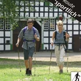 Nordic Walking - sportlich Zwei Personen nordic walken fröhlich vor einem historischen Fachwerkgebäude bei sonnigem Wetter.