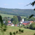 Ausblick auf das Amseldorf Merlsheim Blick über eine grüne Wiese auf die malerische Ortschaft Merlsheim, umgeben von sanften Hügeln.