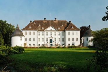 Schloss Vinsebeck, ein barockes Wasserschloss, umgeben von einer gepflegten Rasenfläche und zwei Türmen.