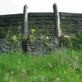 Wallanlage Nachbau Nachbau einer historischen Wallanlage aus Holz und Stein, umgeben von grüner Vegetation.