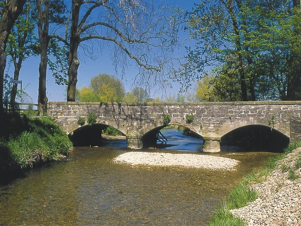 Heubachbrücke Steinheim Historische Steinbrücke mit drei Bögen spannt sich über einen sanft fließenden, klaren Bach.