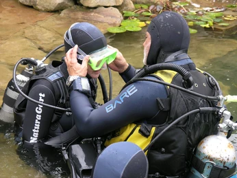 Tauchkurs im NaturaGart-Park Zwei Taucher im NaturaGart-Park, einer hilft dem anderen bei der Einstellung der Taucherbrille.
