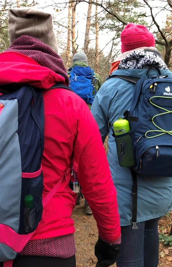 Mehrere Wanderer in bunter Outdoorkleidung auf einem Pfad im herbstlichen, bewaldeten Gelände.Several hikers in colorful outdoor clothing on a path in autumnal, wooded terrain.Flere vandrere i farverigt udendørstøj på en sti i et efterårsagtigt, skovklædt terræn.Verschillende wandelaars in kleurrijke outdoorkleding op een pad in herfstachtig, bebost terrein.