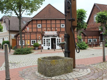 Historisches Fachwerkhaus mit Schriftzug "KAFFEEHAUS", umgeben von Pflastersteinen und Bäumen.Historic half-timbered house with "KAFFEEHAUS" lettering, surrounded by cobblestones and trees.Historisk bindingsværkshus med "KAFFEEHAUS"-bogstaver, omgivet af brosten og træer.Historisch vakwerkhuis met "KAFFEEHAUS"-belettering, omgeven door kinderkopjes en bomen.
