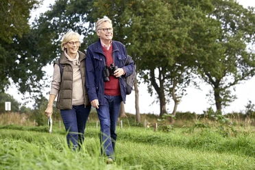 Nord-Ostsee-Wanderweg Zwei Personen wandern auf grasigem Weg