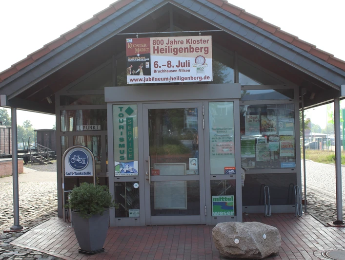 TI Bruchhausen-Vilsen Tourist-Information Bruchhausen-Vilsen, modernes Eingangshäuschen mit Plakaten und Fahrradverleih.
