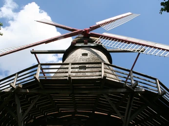 Mühle Eystrup Historische Mühle mit rot-weißen Flügeln und hölzernem Balkon vor blauem Himmel im Eystrup.Historic mill with red and white wings and wooden balcony against a blue sky in Eystrup.Historisk mølle med røde og hvide vinger og træbalkon mod en blå himmel i Eystrup.Historische molen met rode en witte wieken en houten balkon tegen een blauwe lucht in Eystrup.